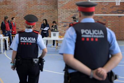 Una pareja de los Mossos, el domingo en un colegio electoral en Figueres.