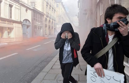 Manifestantes se protegen el rostro de los botes de humo lanzados durante la manifestación contra la reforma laboran en Rennes (Francia), el 31 de marzo de 2016.