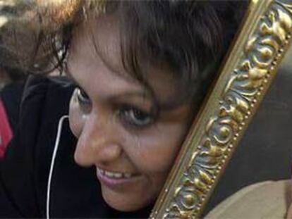Una mujer sostiene el retrato de Pinochet a las afueras del hospital militar.