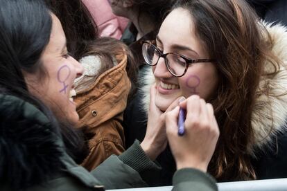 A woman paints the Venus symbol on her friend’s face at the Pontevedra demonstration.