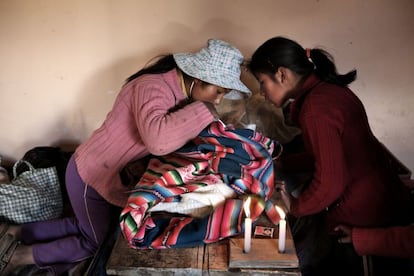 "Un día llegué al hospital de Patacamaya y una enfermera me dijo que una madre había tenido un bebé muerto porque, debido a su miedo a la medicina biomédica, no fue al hospital antes. Primero estuve con la madre, Andrea París Mamami, y luego acompañé a los vecinos de su pueblo, Belén Iquiaca, muy cerca de Patacamaya. Las circunstancias de esta familia eran muy duras porque el marido de Andrea tenía problemas con el alcohol, casi nunca estaba en casa y, cuando el niño nació muerto, desapareció, yo no le pude conocer. La pareja vivía con sus dos hijas en una casa prestada, una especie de almacén pequeñito de barro con techo de uralita, una cama grande y lleno de trastos. Cuando llegué no había nadie más de la familia, solo las hijas y dos vecinos que se hicieron cargo de enterrar al bebé muerto. En la foto se ve a las dos hijas, Segundina, de 12 años, e Iliana, de ocho, mirando sorprendidas el cadáver de su hermano".