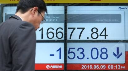 Un hombre pasa ante una pantalla con el índice Nikkei en Tokio.