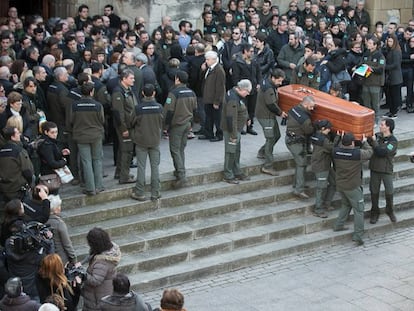 Compañeros de los agentes trasladan el féretro de una de las víctimas en su funeral.