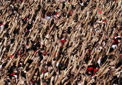 Centenas de pessoas alçam seus braços ao som de gaiteiros, durante a abertura oficial da festa de São Firmino, em Pamplona.