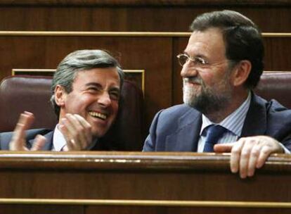 El presidente del Partido Popular, Mariano Rajoy, acompañado por el secretario general del PP, Ángel Acebes, es ovacionado durante por los diputados populares al ocupar hoy su sitio en el Congreso.