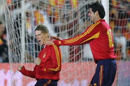 Torres celebra el primer gol de España, marcado por él de penalti, mientras Luque le felicita sujetándole por los hombros.