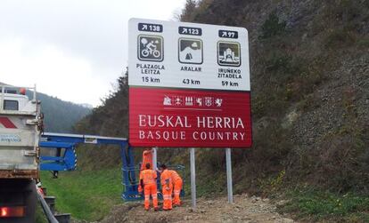 Operarios colocan un cartel en la carretera que une Gipuzkoa con Navarra.