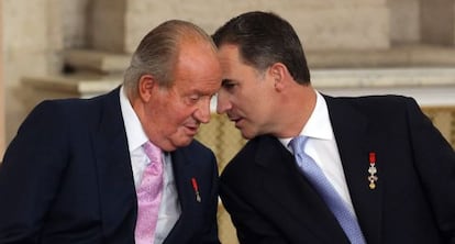 Juan Carlos I con su hijo, Felipe VI, el 18 de junio de 2014, en el acto de sanción de la ley de abdicación en el Palacio Real.