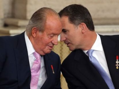 Juan Carlos I con su hijo, Felipe VI, el 18 de junio de 2014, en el acto de sanción de la ley de abdicación en el palacio Real.