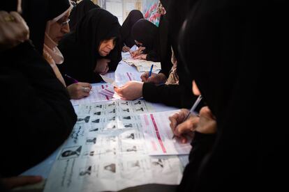 Mujeres rellenan sus papeletas durante la elecciones legislativas en un colegio electoral del sur de Teherán.