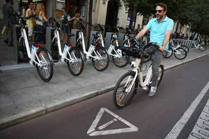 Un hombre con una bicicleta BiciMad por un carril bici de Madrid. A principios de 2016, el sistema contaba ya con más de 55.000 abonados.