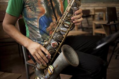  Un joven de la Orquesta de Instrumentos Reciclados de Cateura en Asunción (Paraguay) toca el 30 de diciembre de 2013 un saxofón hecho con una tubería vieja y otros desechos.  