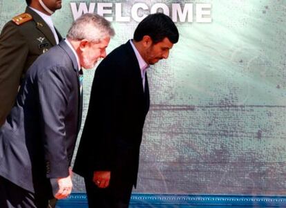 El presidente iraní Mahmud Ahmadineyad y su homólogo brasileño Luiz Inácio Lula da Silva escuchan los himnos nacionales antes de la reunión que han mantenido en el palacio presidencial de Teherán