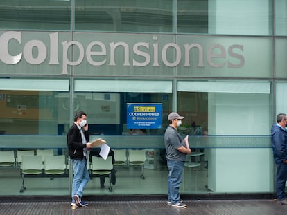 Personas hacen fila afuera de una sucursal de Colpensiones, en una imagen de archivo.