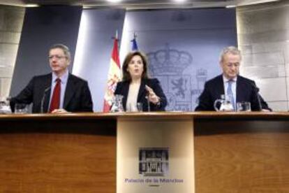 La vicepresidenta del Gobierno, Soraya Sáenz de Santamaría, y los ministros de Justicia, Alberto Ruiz-Gallardón (i), y Defensa, Pedro Morenés, en la rueda de prensa posterior a la reunión del Gobierno, hoy.