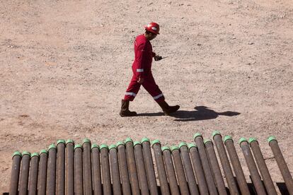 Un operario camina junto a unos tubos de las torres de perforación y 'fracking' para la extracción de petroleo y gas no convencional.