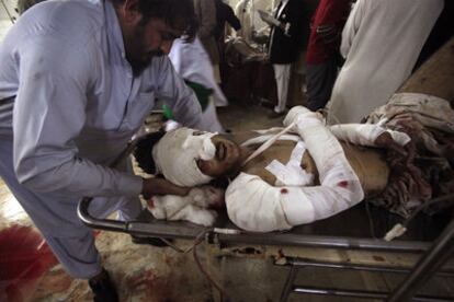Un herido es trasladado en camilla tras el doble atentado suicida en Pakistán.