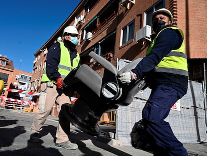 Dos operarios retiran los enseres durante el desalojo de las cuatro viviendas de la calle Presa en San Fernando de Henares (Madrid).