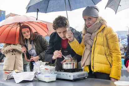 Una familiar de un concursante protege a este e la lluvia con un paraguas en la última prueba presencial para 'MasterChef' 6 en Getafe.