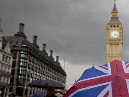 Una persona con un paraguas con la bandera de Reino Unido, delante del parlamento brit&aacute;nico.