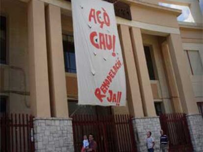 Una pancarta denuncia, en la fachada del instituto Ausiàs March, el deplorable estado del edificio.