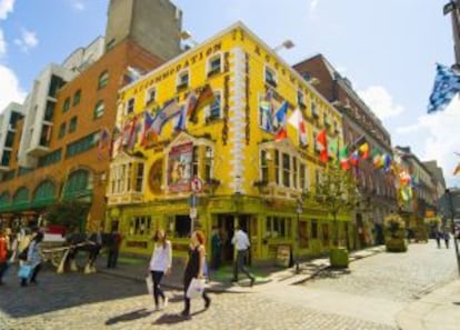 Jóvenes pasan por delante de un 'pub' en Dublín, Irlanda.