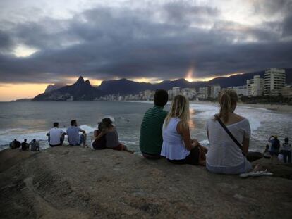 Turistas observam o p&ocirc;r do sol no Arpoador, no Rio.