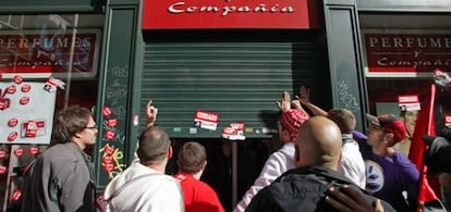 Un grupo de manifestantes delante de un comercio en la Gran Vía madrileña.