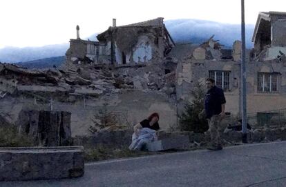 Una parella camina pels carrers del poble d'Amatrice després del tremolor que ha sacsejat el centre d'Itàlia la matinada d'aquest dimecres.