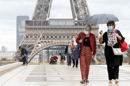 Varias personas, frente a la torre Eiffel, una de las grandes atracciones turísticas de París.