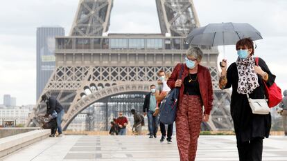 Varias personas, frente a la torre Eiffel, una de las grandes atracciones turísticas de París.