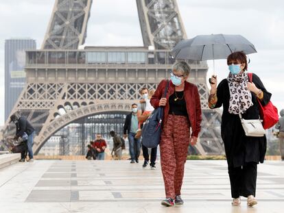 Varias personas, frente a la torre Eiffel, una de las grandes atracciones turísticas de París.