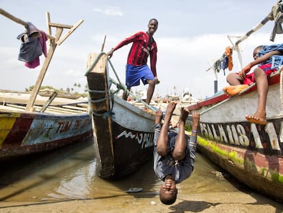 Niños ghaneses juegan junto a barcos de pesca.