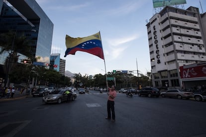 Un hombre alza una bandera venezolana durante una vigilia en homenaje a los caídos en las manifestaciones del 30 de abril y 1 de mayo, en Caracas (Venezuela).