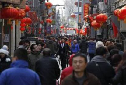 Turistas pasean por el distrito de Qianmen decorado con lámparas rojas durante el quinto día de la celebración del Año Nuevo del Caballo en Pekín.