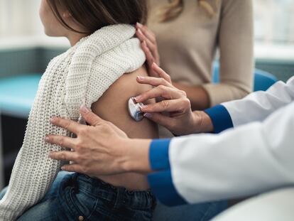 Una pediatra examina a una niña en su consulta.