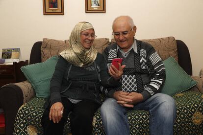 Ana Lobato and her husband Abdalazem Alfaraj Al Shoeib, looking at photos of their children in Madrid.