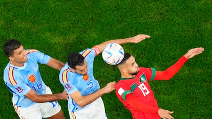 Rodri (izquierda), Sergio Busquets (centro) y Youssef En-Nesyri (derecha) tratan de cabecear un balón aéreo durante el encuentro de octavos de final entre España y Marruecos. 