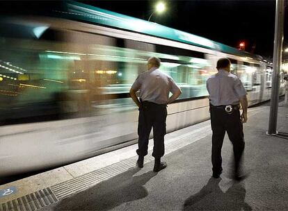 Dos vigilantes de seguridad inspeccionan, la madrugada del viernes al sábado, la estación del tranvía de Sant Adrià de Besòs.