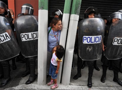 Una mujer observa, entre los antidisturbios, la manifestación de ayer contra el presidente Colom.