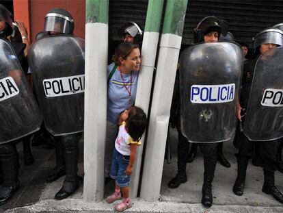 Una mujer observa, entre los antidisturbios, la manifestación de ayer contra el presidente Colom.