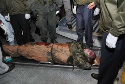 Agentes de la policía observan el cadáver del Mono Jojoy en el aeropuerto militar de Catam, en Bogotá, el jueves.