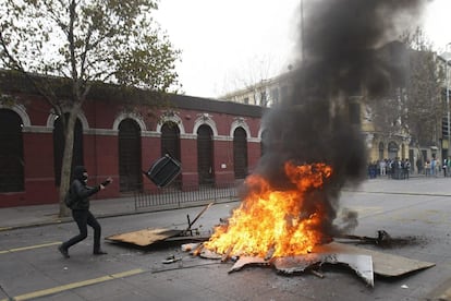 Un manifestante enciende una barricada durante la protesta de este jueves. El pasado 15 de mayo dos estudiantes fueron asesinados en Valparaíso durante una de las manifestaciones que se realizaron en diferentes ciudades chilenas para reclamar al Gobierno de Michelle Bachelet una reforma de la educación.