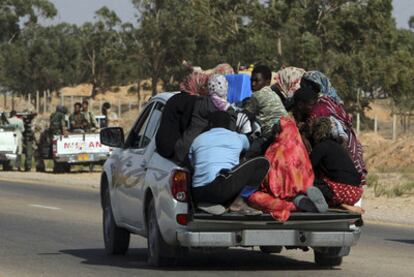 Un grupo de refugiados huye de Sirte por los enfrentamientos entre rebeldes y gadafistas.