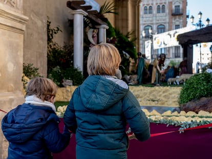 Unos niños contemplan el belén colocado en el Ayuntamiento de Sevilla.