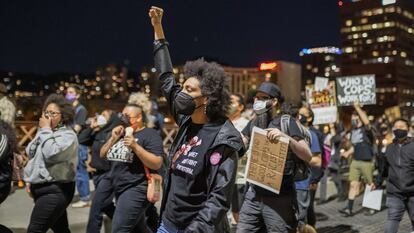 Manifestantes marcham ao longo da ponte Hawthorne depois que policiais atiraram em um sem-teto no Lents Park em 16 de abril de 2021, em Portland, Oregon.