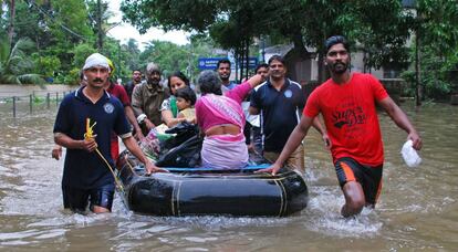 Voluntarios indios y personal de rescate evacúan a unos residentes en Kozhikode (Kerala).