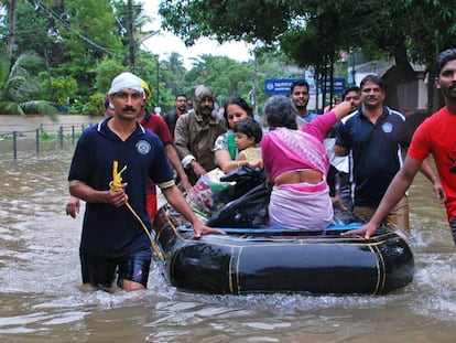 Voluntarios indios y personal de rescate evacúan a unos residentes en Kozhikode (Kerala).
