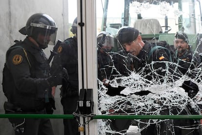 Agentes de la Policía Nacional rompen el cristal de un colegio en Sant Juliá de Ramis para acceder al centro.