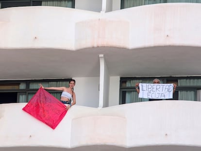 Two youngsters confined at Palma Bellver hotel in Mallorca hold signs saying “We are negative, we want to leave!” and “Freedom Écija."